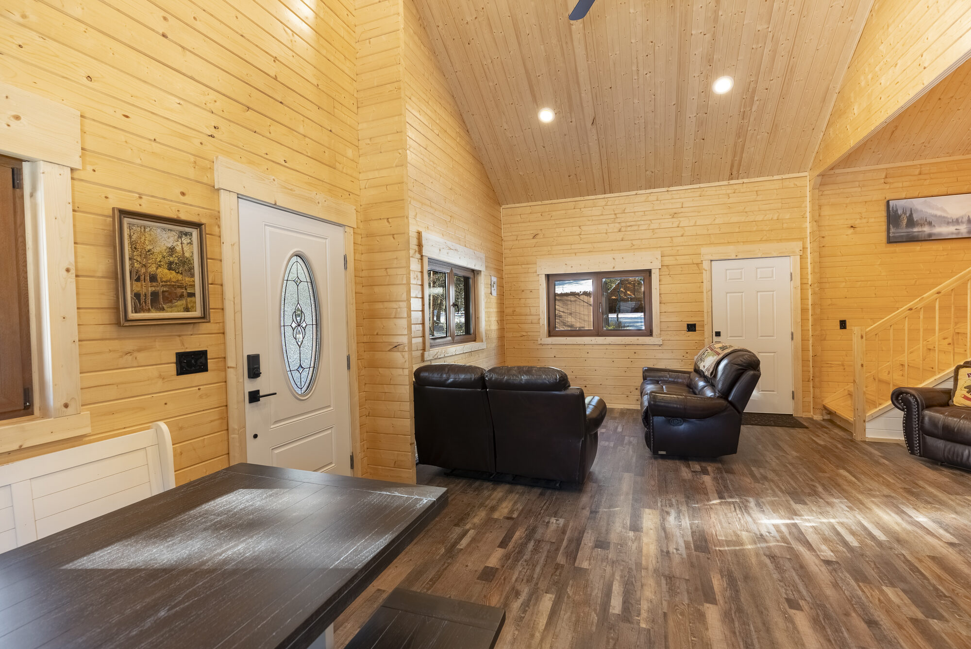 Log cabin entryway and living room with vaulted ceiling